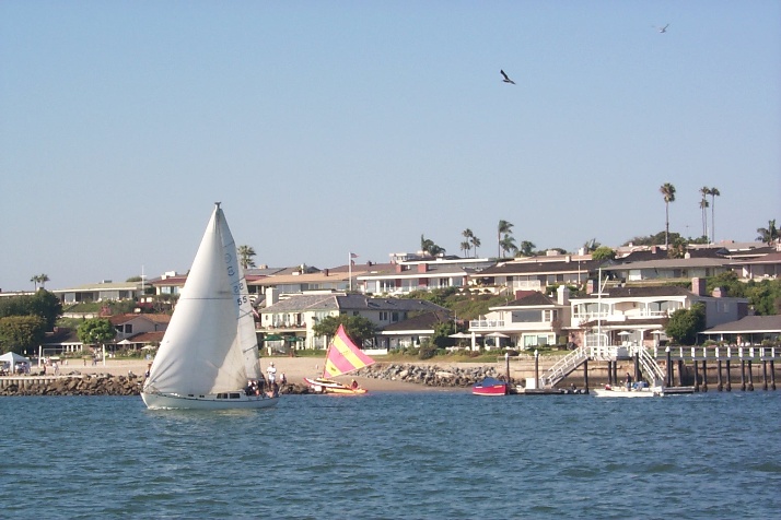 Waterfront homes with sailboat in foreground